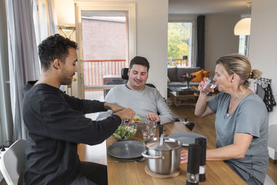 Mother with adult sons having meal