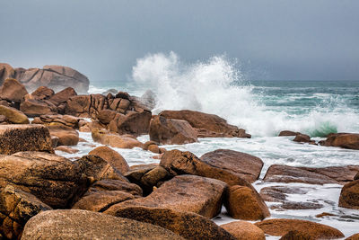 Scenic view of sea splashing against rocks