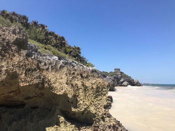 Scenic view of rocks against clear blue sky