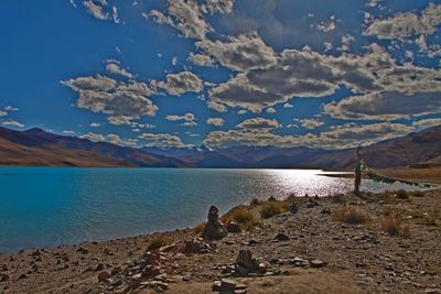 Scenic view of sea and mountains against sky