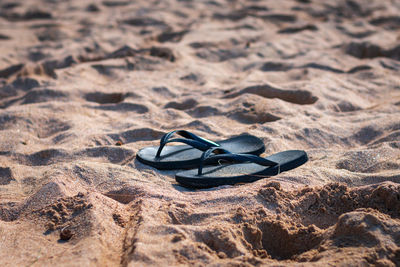 Close-up of shoes on sand