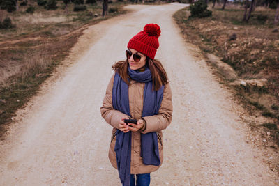 Full length of young woman standing on road