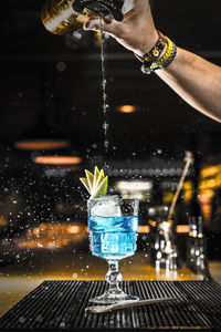 Midsection of person pouring water in glass