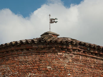 Low angle view of weather vane against sky