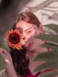 Portrait of young woman with flower outdoors