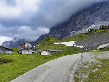 Road by buildings against sky