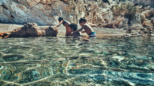 People splashing water in rocky mountains