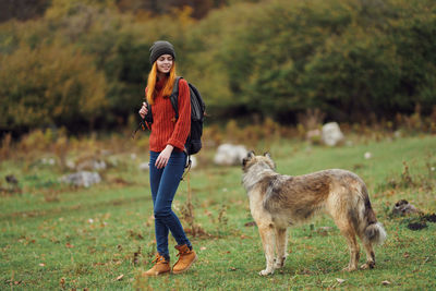 Full length portrait of young woman standing on land