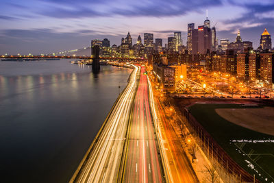 High angle view of light trails on city street by east river at dusk