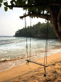 View of swing on beach against sky