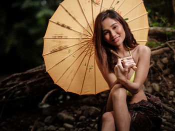 Portraiture shot of a beautiful asian female model in bikini at a river