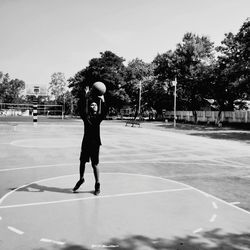 Full length of teenage boy playing basketball