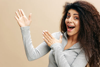 Portrait of woman against beige background