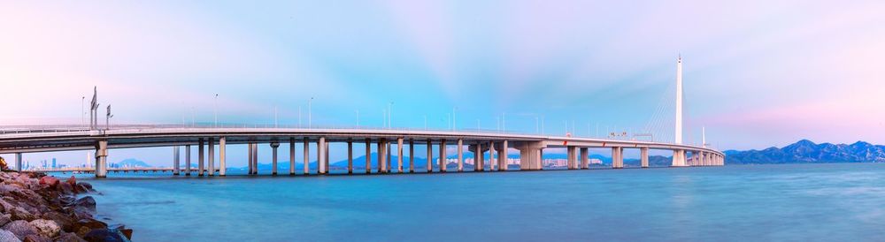 Bridge over sea against blue sky