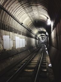 Railroad tracks in illuminated tunnel