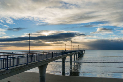 Pier over sea against sky during sunset