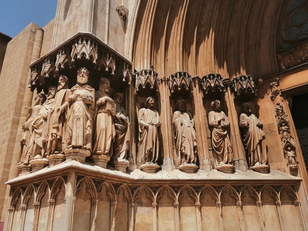 LOW ANGLE VIEW OF STATUES ON TEMPLE AGAINST CATHEDRAL