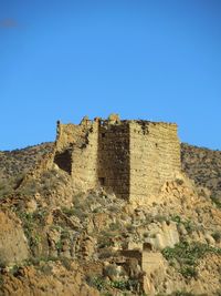 Low angle view of fort against clear blue sky