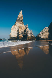Scenic view of beach against blue sky