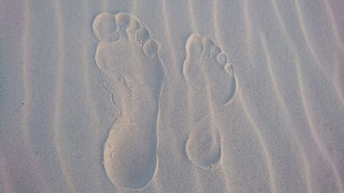 High angle view of footprints on sand at beach