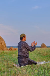 Man wearing hat on field against sky