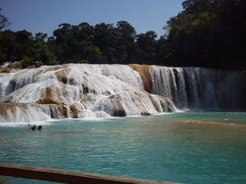 Scenic view of waterfall against sky