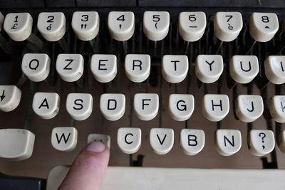 Cropped image of person typing on typewriter