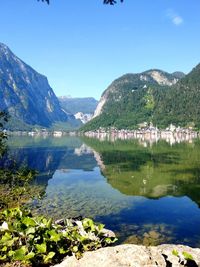 Scenic view of lake and mountains against blue sky