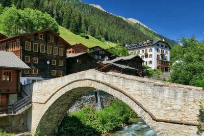 Arch bridge over buildings against sky
