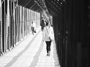 Rear view of women walking on footpath