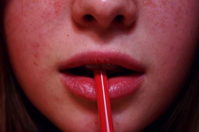 Close-up of woman with drinking straw