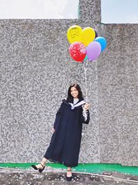 Full length of a smiling young woman holding umbrella