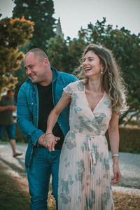 Couple embracing against trees