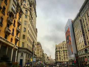 Low angle view of buildings against cloudy sky