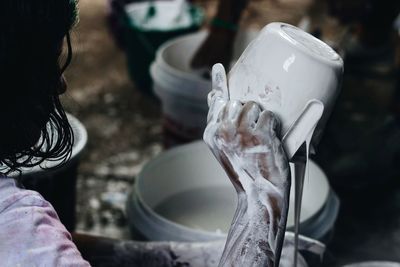 Close-up of craftsperson with messy hand at workshop