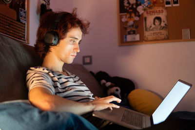 Man using laptop while sitting in darkroom