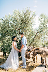 Young couple kissing against trees