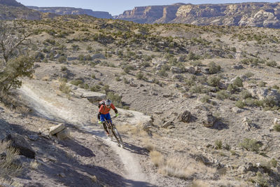 Full length of man climbing on mountain against sky