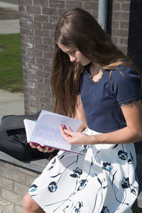 Student girl teenager reads notes before the lesson of recess