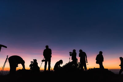 Silhouette people against sky during sunset