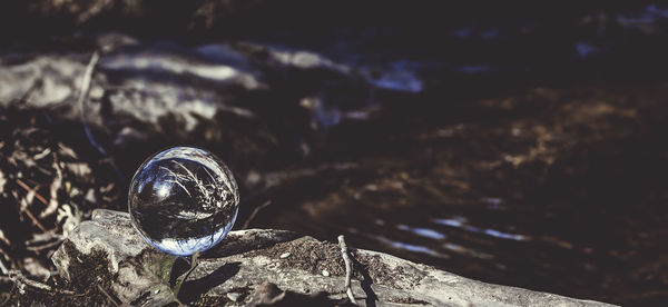 Close-up of crystal ball at lakeshore