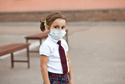 Portrait of young woman standing against wall