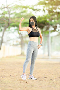 Full length portrait of young woman standing outdoors