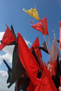 Low angle view of colorful flags against sky