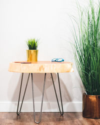 Potted plant on table against wall