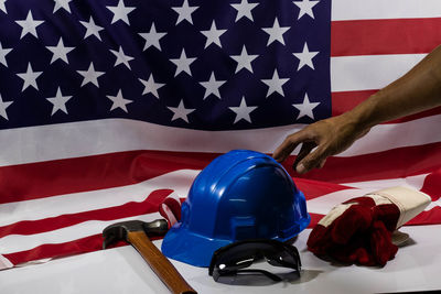 Cropped hand touching hardhat against american flag