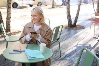 Young woman using laptop at cafe