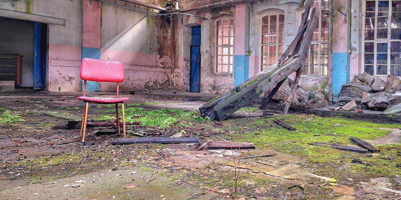 ABANDONED CHAIR AGAINST HOUSE