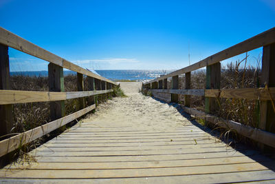 View of empty footpath leading towards beach