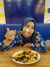 Portrait of young woman sitting at restaurant